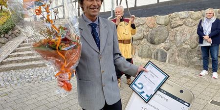 Modtageren af Kulturpris 2022, Jørgen Christensen, med blomster, diplom og mobilepay-bevis. Foto: Frederikssund Kommune.