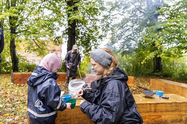 Naturvejleder laver brød med urter sammen med en pige. Foto: Frederikssund Kommune, Kenneth Jensen.