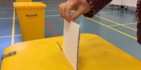 Hånd lægger stemmeseddel i valgurnen. Foto: Frederikssund Kommune.