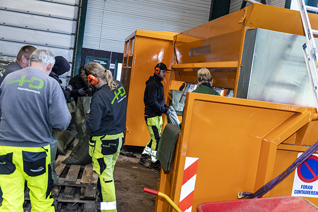 Medarbejdere fylder sandsække ved maskinen. Foto: Frederikssund Kommune, Kenneth Jensen.