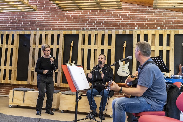 Kvinde synger mens to mænd spiller musik. Foto: Frederikssund Kommune, Kenneth Jensen.