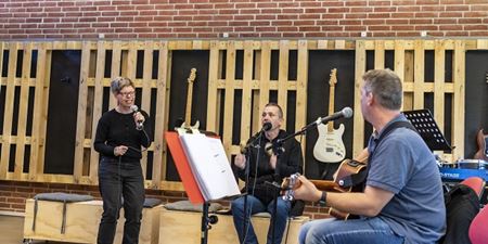 Kvinde synger mens to mænd spiller musik. Foto: Frederikssund Kommune, Kenneth Jensen.