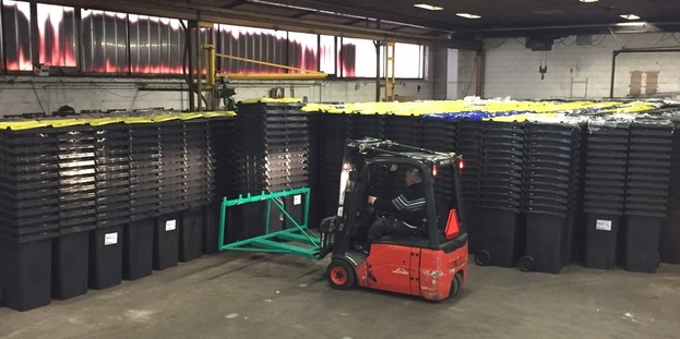 Truck sætter affaldsbeholdere i stakke på lageret i Jægerspris. Foto: Frederikssund Kommune.