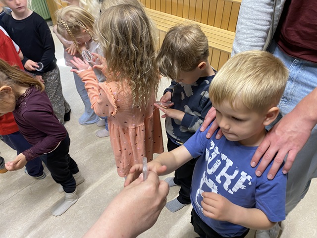 Sofie uddeler forstørrelsesglas til børnene. Foto: Frederikssund Kommune.