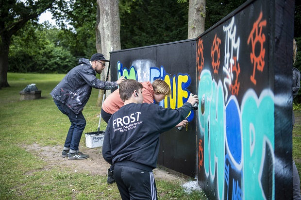Unge maler graffiti på graffitiworkshop. Foto: Frederikssund Kommune, Kenneth Jensen.