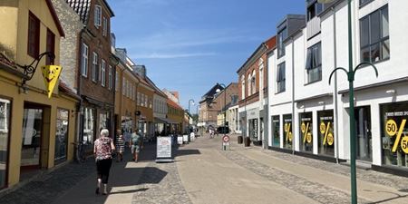 Jernbanegade i Frederikssund med butikker, gadeskilte og mennesker i gaden. Foto: Frederikssund Kommune.