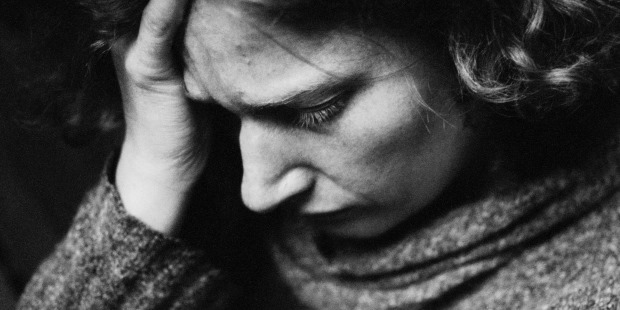 Kvinde tager sig til hovedet. foto: Colourbox.