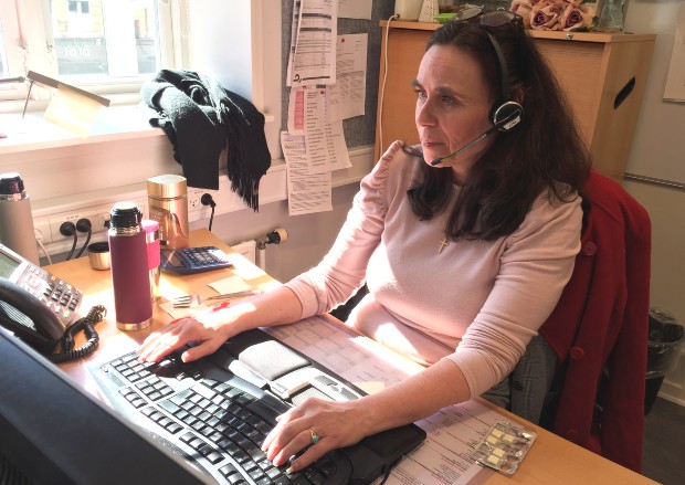 Helene Garly på arbejde i callcenteret med headset foran sin pc. Foto: Frederikssund Kommune.