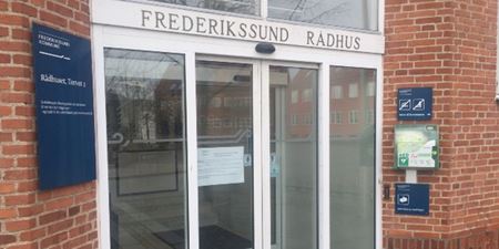 Rådhusets hovedindgang med et skilt i døren, der fortæller, at der er lukket for personlige henvendelser. Foto: Frederikssund Kommune.