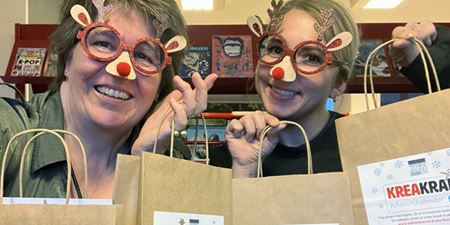 To udklædte personer med papirsposer med kreative materialer. Foto: Frederikssund Kommune.