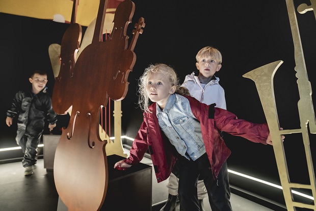 Børn kigger på træudskæringer af instrumenter. Foto: Det Kongelige Teater, Camilla Winther.