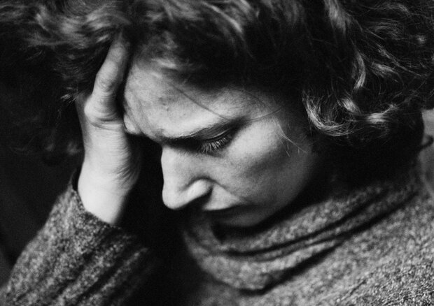 Kvinde tager sig til hovedet. Foto: Colourbox.