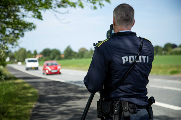 Betjent måler bilers fart i siden af vejen. Foto: Rådet for Sikker Trafik.