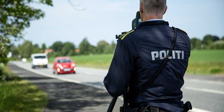 Betjent måler bilers fart i siden af vejen. Foto: Rådet for Sikker Trafik.