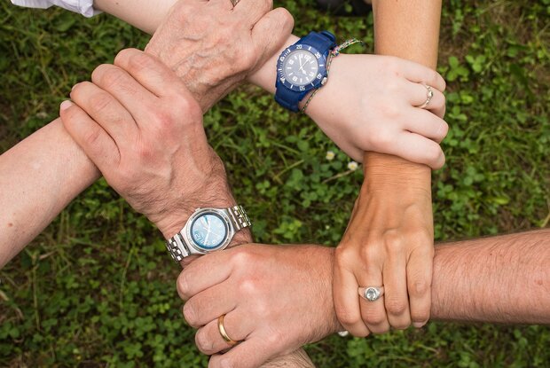 Fem hænder holder om hinandens håndled Foto: Pixabay.