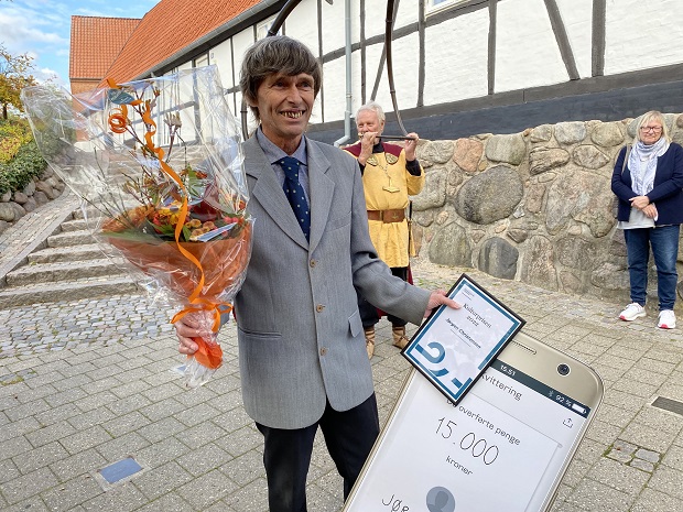 Modtageren af Kulturpris 2022, Jørgen Christensen, med blomster, diplom og mobilepay-bevis. Foto: Frederikssund Kommune.