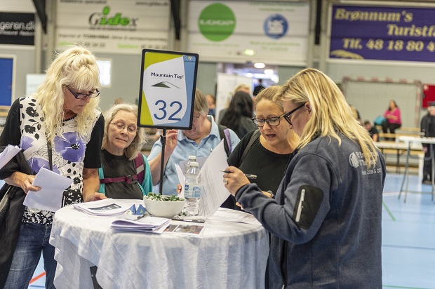 Fem kvinder ved et rundt cafébord, hvorpå der står et skilt med ordene Mountain Top og tallet 32. Foto: Frederikssund Kommune, Kenneth Jensen.