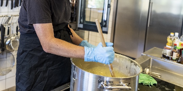 Person rører i stor gryde i industrielt køkken. Foto: Frederikssund Kommune, Kenneth Jensen.