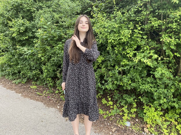 Marharyta Kurchenko foran en hæk og ved at fjerne sit lange hår fra ansigtet. Foto: Frederikssund Kommune, Mikala Schachtschabel Tordrup.