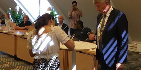 Erklæringen bliver underskrevet af den nye statsborger, mens en pårørende filmer det hele. Foto: Frederikssund Kommune.