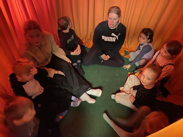 Børnene sidder i lytterummet, som er orange og dufter af appelsin. Foto: Mikala Tordrup.