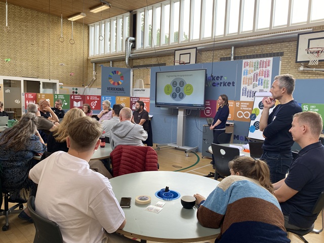 En række lærere sidder omkring nogle borde til workshop og kigger op mod en underviser. Foto: Frederikssund Kommune