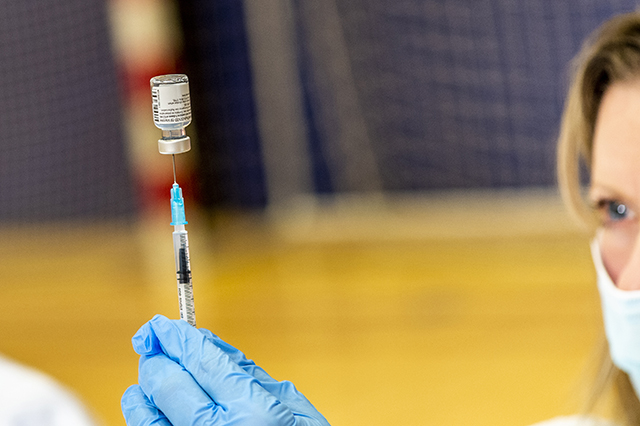 Sygeplejerske holder kanyle med vaccineglas fra Pfizer-BioNTech i hånden. Foto: Kenneth Jensen, Frederikssund Kommune.