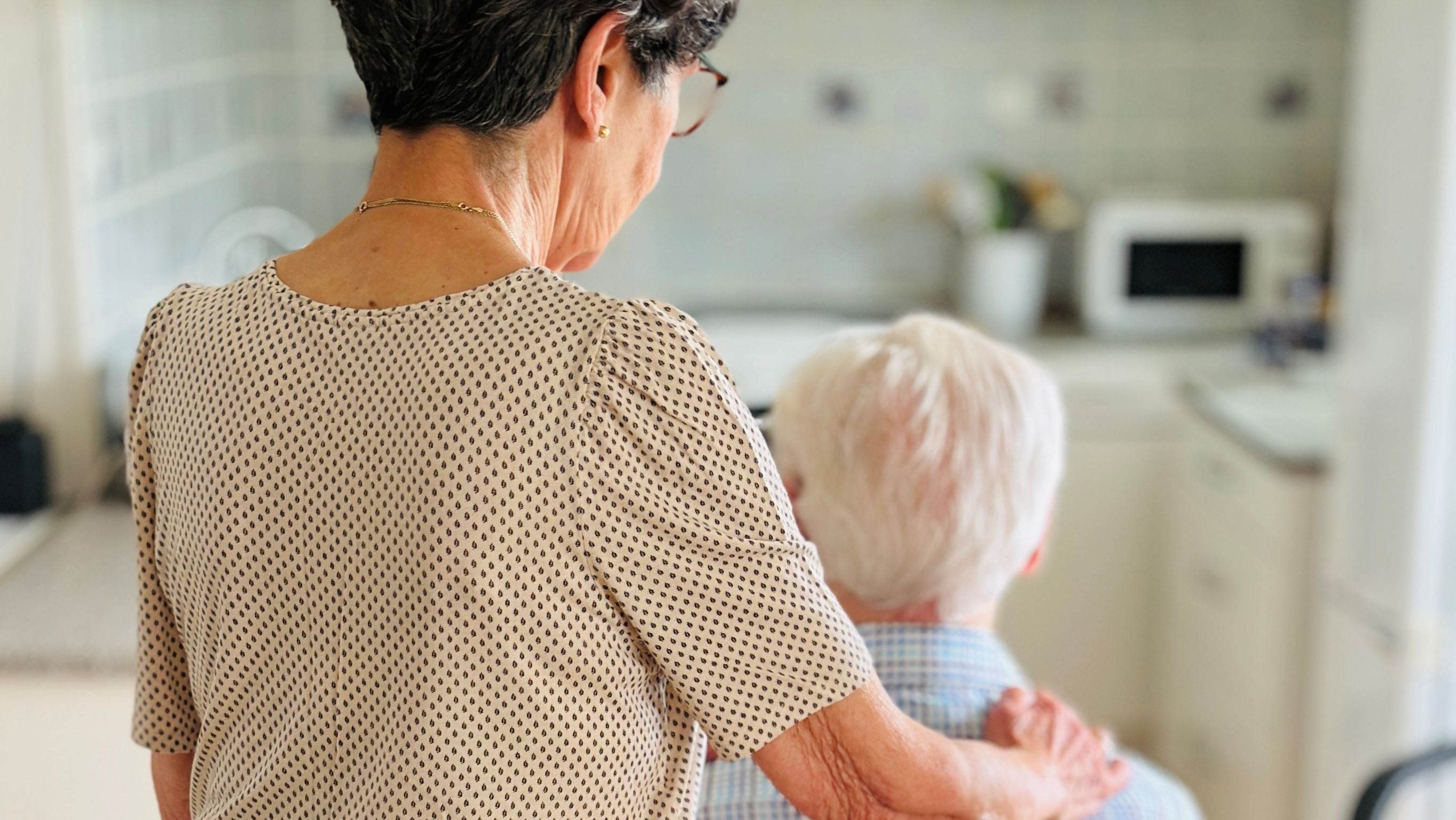 Ældre kvinde med hånd på ældre mands skulder
