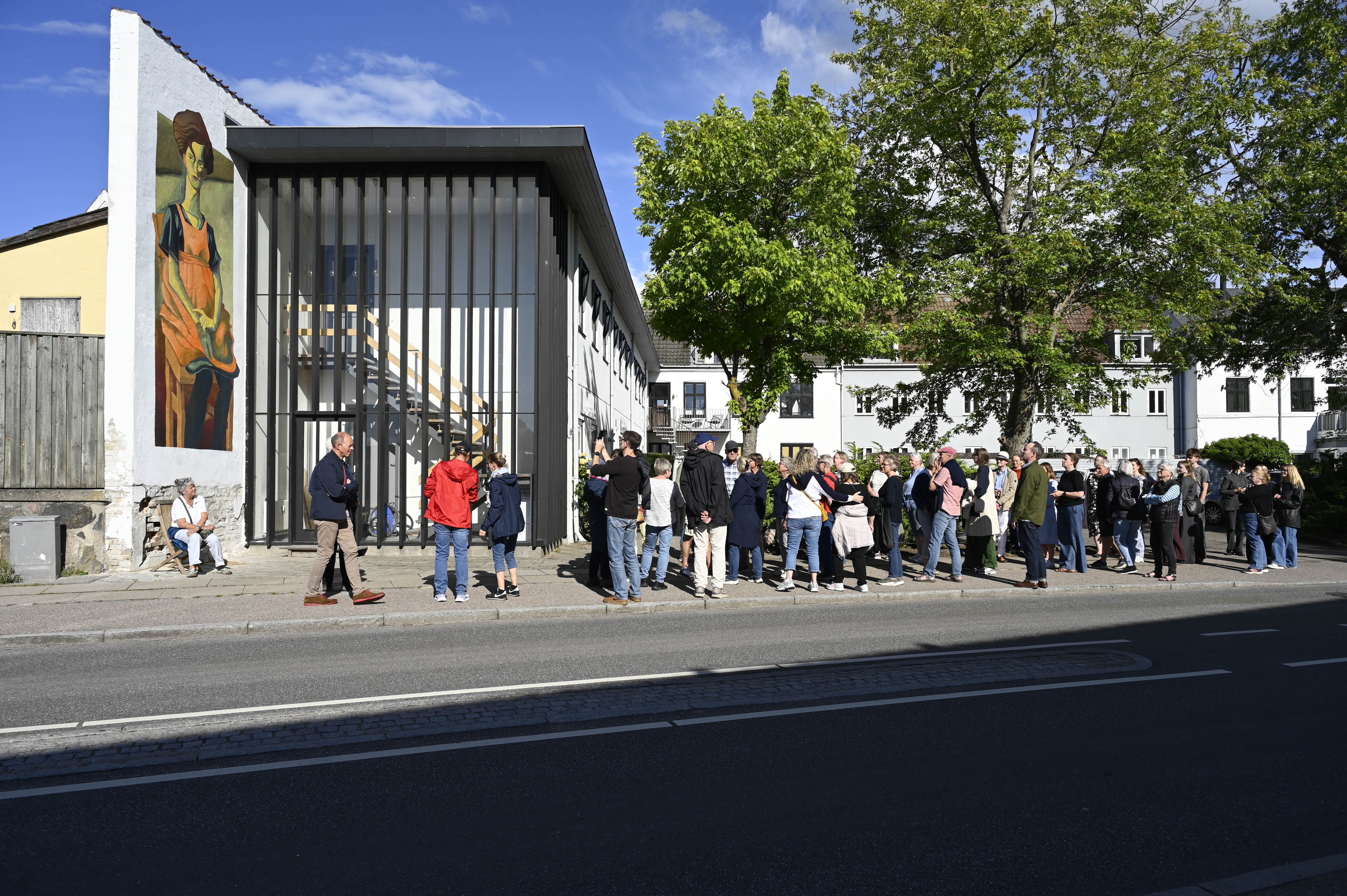 En gruppe mennesker kigger på gavlmaleri. Foto: Frederikssund Kommune