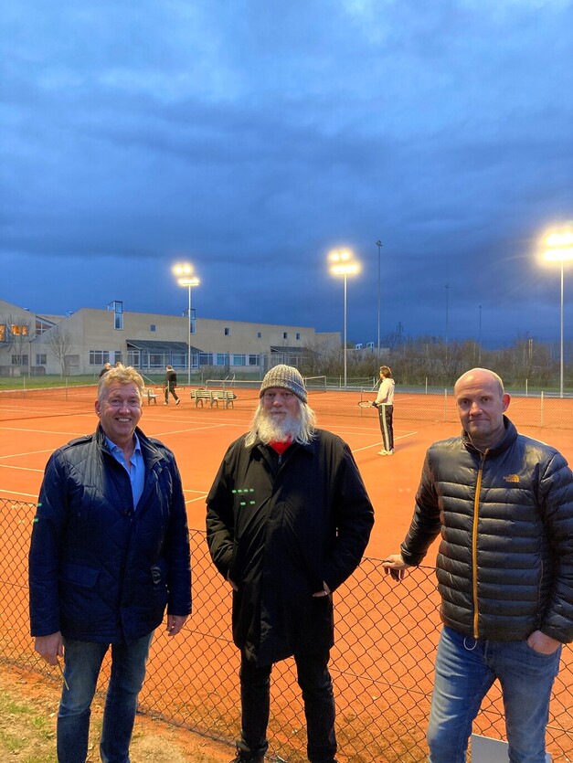 Lysanlægget er nu tændt ved tennisbanerne ved SIK. Fra venstre ses  borgmester John Schmidt Andersen (V), formand for Fritids- og Kulturudvalget Jesper Wittenburg samt formanden for tennisklubben Claus Mahler. Foto: Frederikssund Kommune.