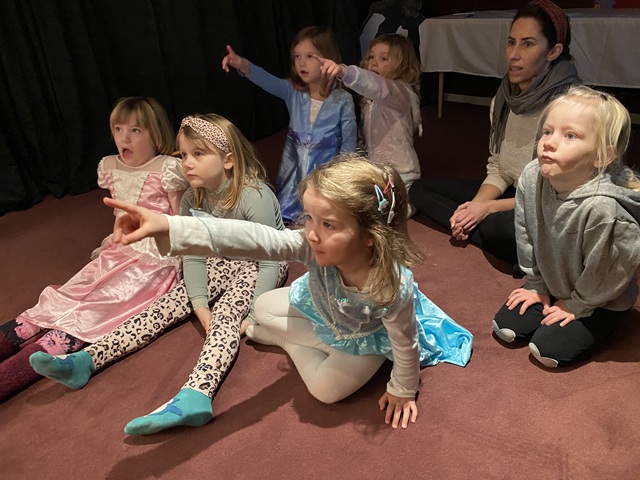 Børnene fra Børnehuset Maglehøj sidder på gulvet og lytter til en fortælling. Nogle gange spørger Seline om noget, og så peger børnene på billedet for at vise svaret. Foto: Mikala Tordrup.