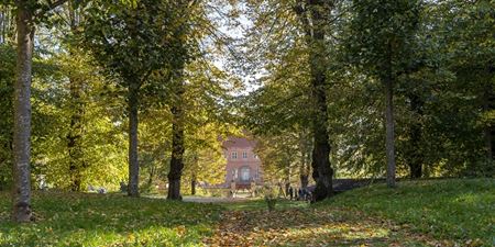 Selsø Slot omhyllet af efterårsfarver i skoven. Foto: Frederikssund Kommune, Kenneth Jensen.