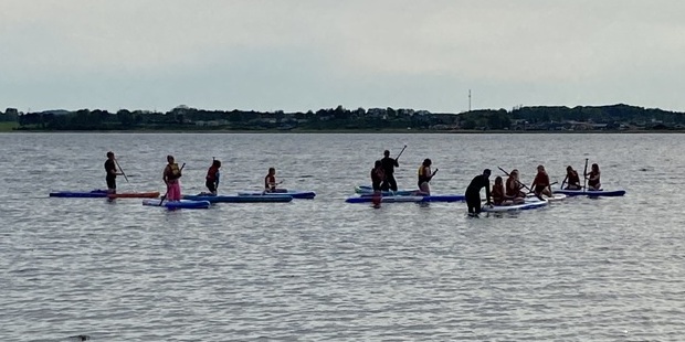 Børn øver på supboards på vandet. Foto: Frederikssund Kommune.