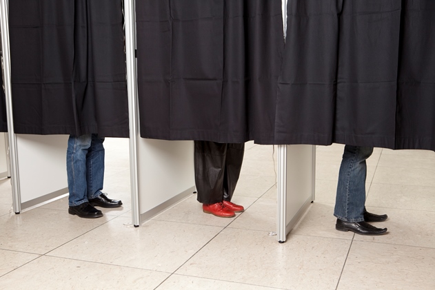 Tre personers ben ses under forhængene i stemmebokse. Foto: Colourbox.