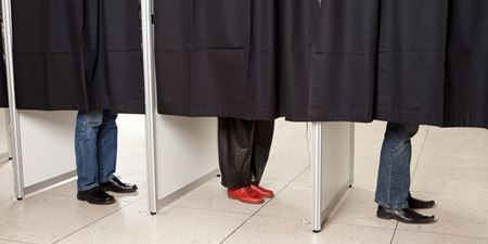 Tre personers ben ses under forhængene i stemmebokse. Foto: Colourbox.