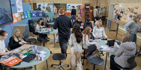Flere unge sidder ved borde og er kreative. Foto: MakerVærket