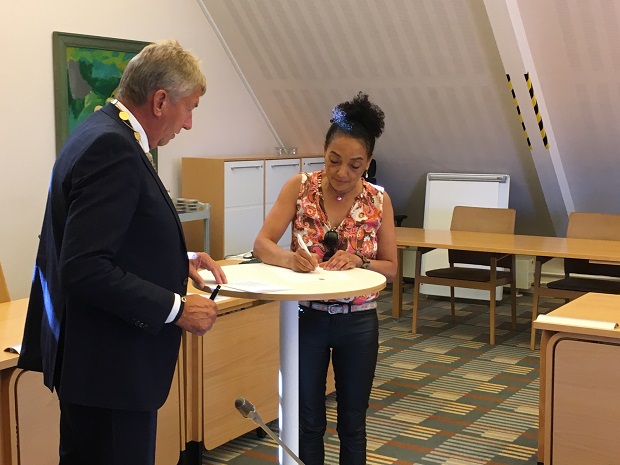 En af de nye kvindelige statsborgere underskriver erklæringen. Foto: Frederikssund Kommune.