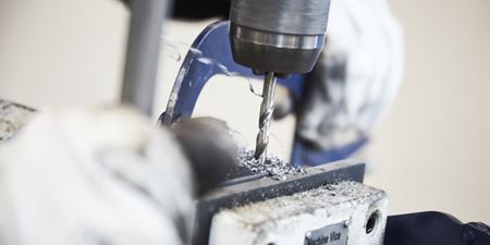 Boremaskine borer i metal. Foto: Frederikssund Kommune.