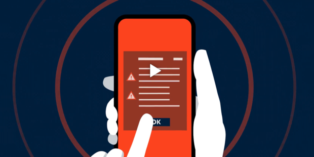 En hånd holder en mobiltelefon.