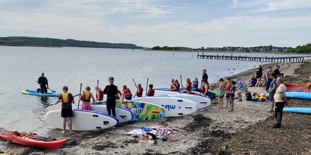 Børn og voksne i strandkanten gør klar til vandsjov. Foto: Frederikssund Kommune.