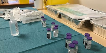 Vacciner i små flasker på et bord med grøn dug. Foto: Frederikssund Kommune.