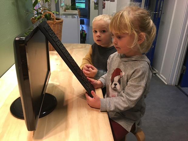 En dreng og en pige står ved en computerskærm og med et tastatur. Foto: Frederikssund Kommune.