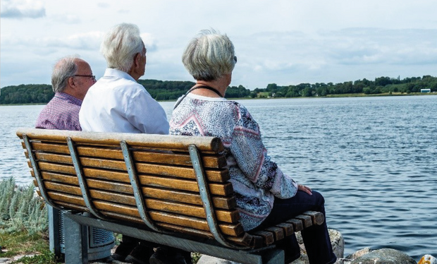 Tre ældre personer sidder på en bænk med udsigt over fjorden. Foto: Frederikssund Kommune, Kenneth Jensen.