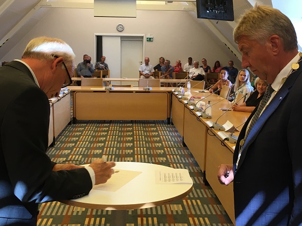 En af de nye borgere underskriver erklæringen, der giver ham sit nye statsborgerskab. Foto: Frederikssund Kommune.