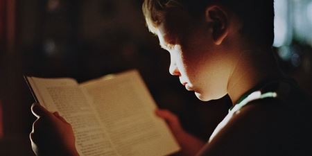 Barn læser i en bog. Foto: Pixabay.