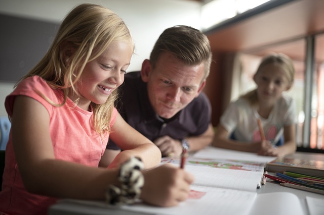 En pige i skolen får hjælp af en mandlig lærer. Foto: Frederikssund Kommune