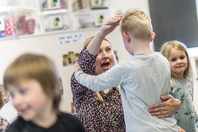 Kvindelig pædagog og dreng leger til musikken og fortællingen. Foto Kenneth Jensen, Frederikssund Kommune.