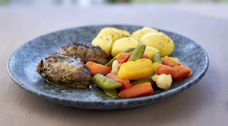 Blå tallerken med kød, kartofler og grøntsager
