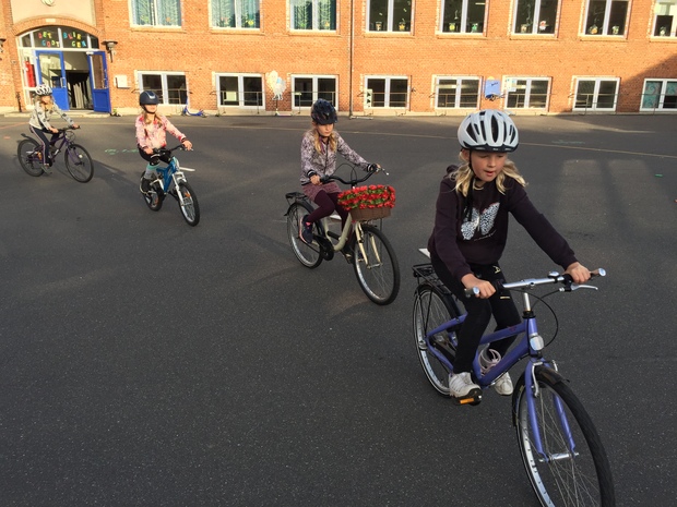 Elever cykler på linje gennem skolegården. Foto: Frederikssund Kommune.