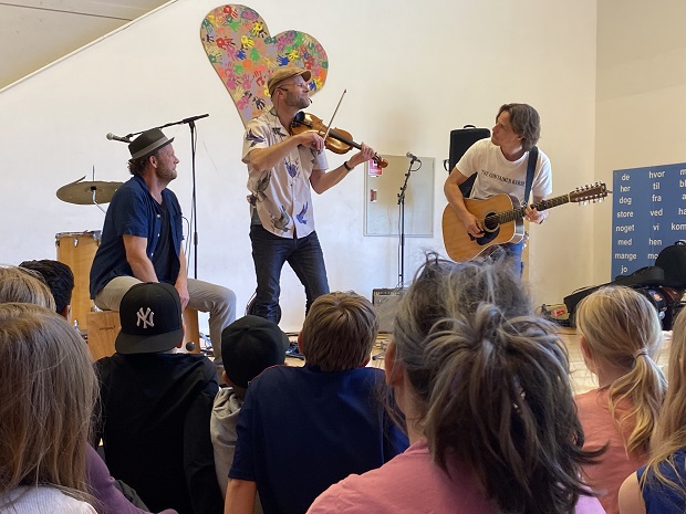 Tumult spiller på deres instrumenter foran elever fra Trekløverskolen. Foto: Frederikssund Kommune.